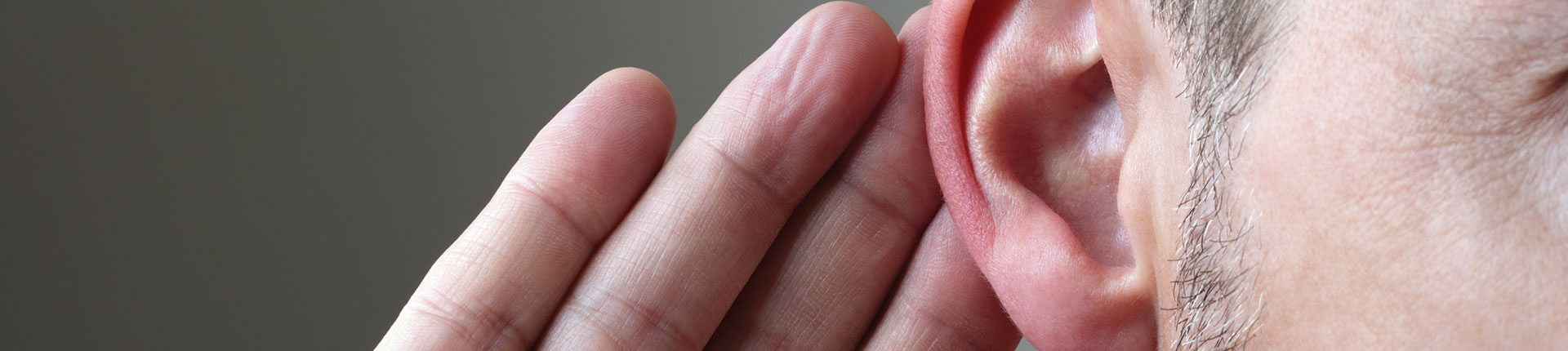 Man Putting Hand Behind Ear Listening due to hearing loss